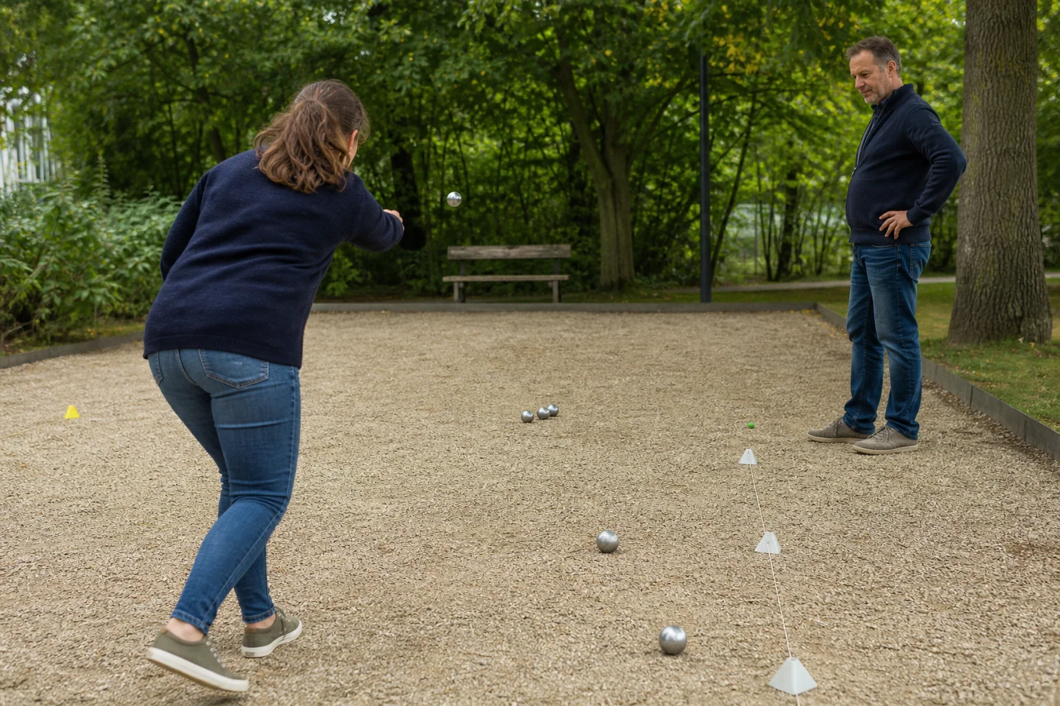 Pétanque-Spieler trainieren Landepunkt und Länge auf einem Bouleplatz